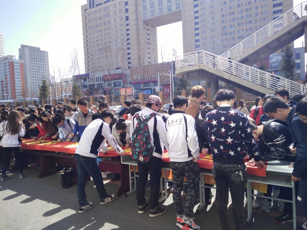 活动现场:往来学生积极在条幅上签名