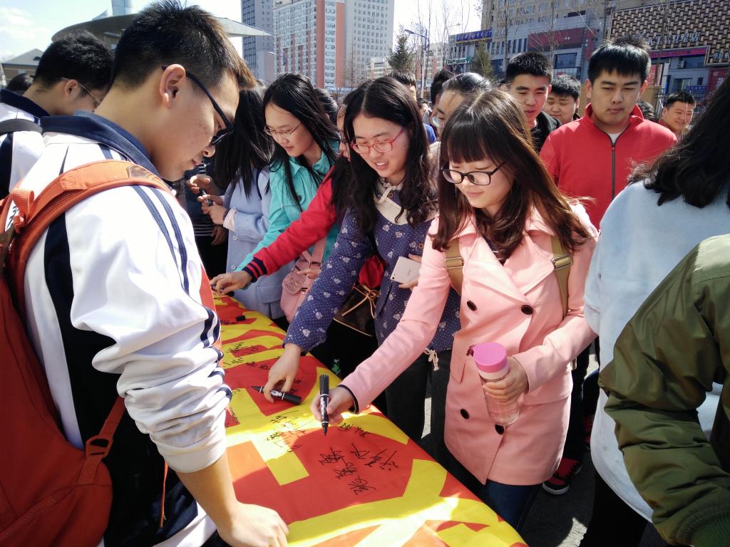 活动现场:往来学生积极在条幅上签名